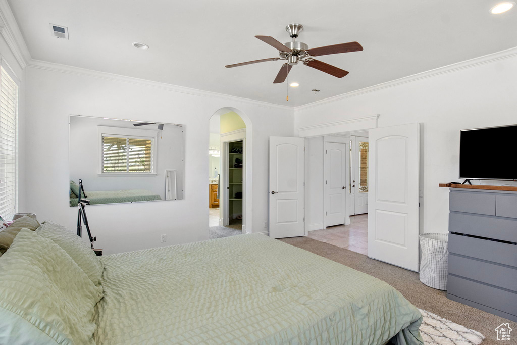 Carpeted bedroom featuring crown molding, arched walkways, recessed lighting, and ceiling fan