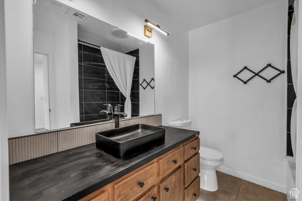 Full bath featuring toilet, tile patterned flooring, vanity, curtained shower, and baseboards