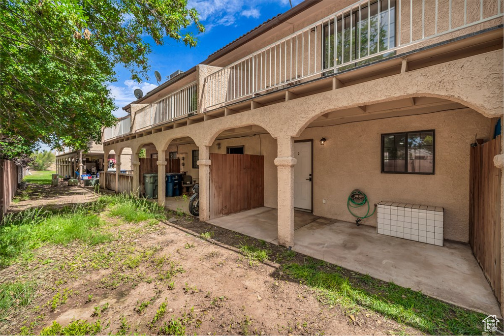 Back of property with a balcony, stucco siding, and a patio