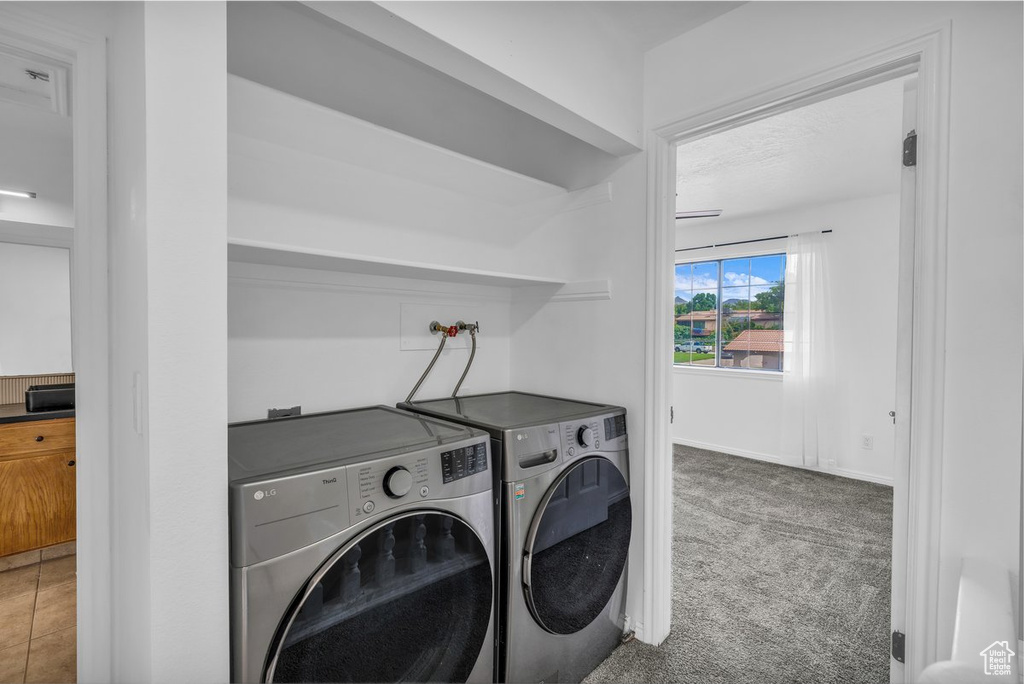 Laundry room with separate washer and dryer and carpet floors