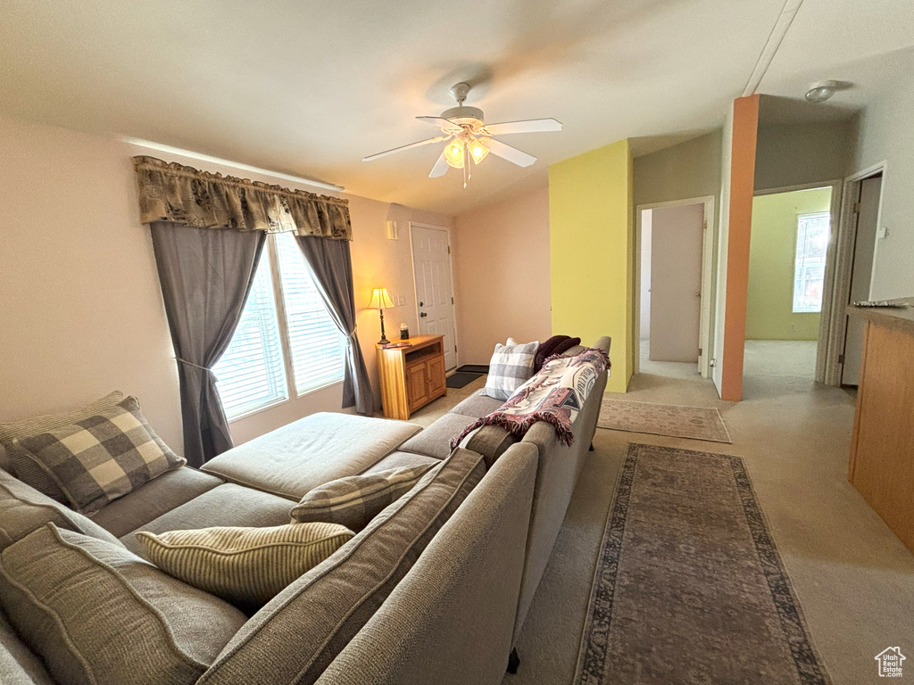 Living area with a ceiling fan and light colored carpet