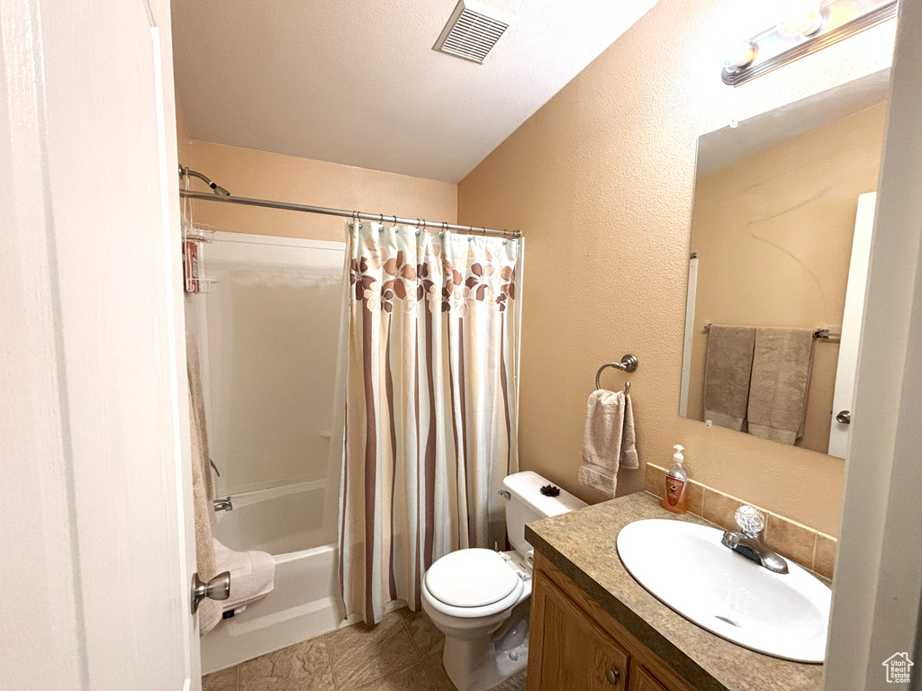 Bathroom featuring toilet, vanity, and shower / bathtub combination with curtain