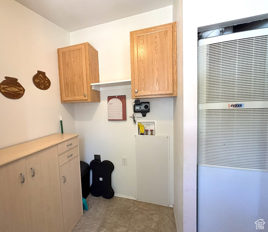 Laundry room with a heating unit, hookup for a washing machine, and baseboards