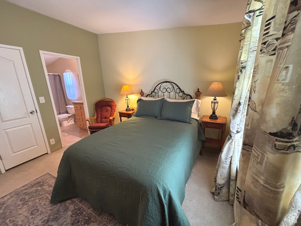Carpeted bedroom featuring ensuite bath