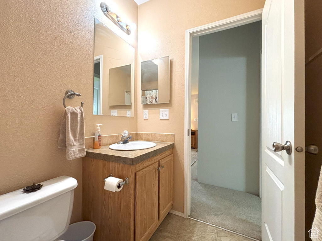 Half bathroom featuring vanity and toilet