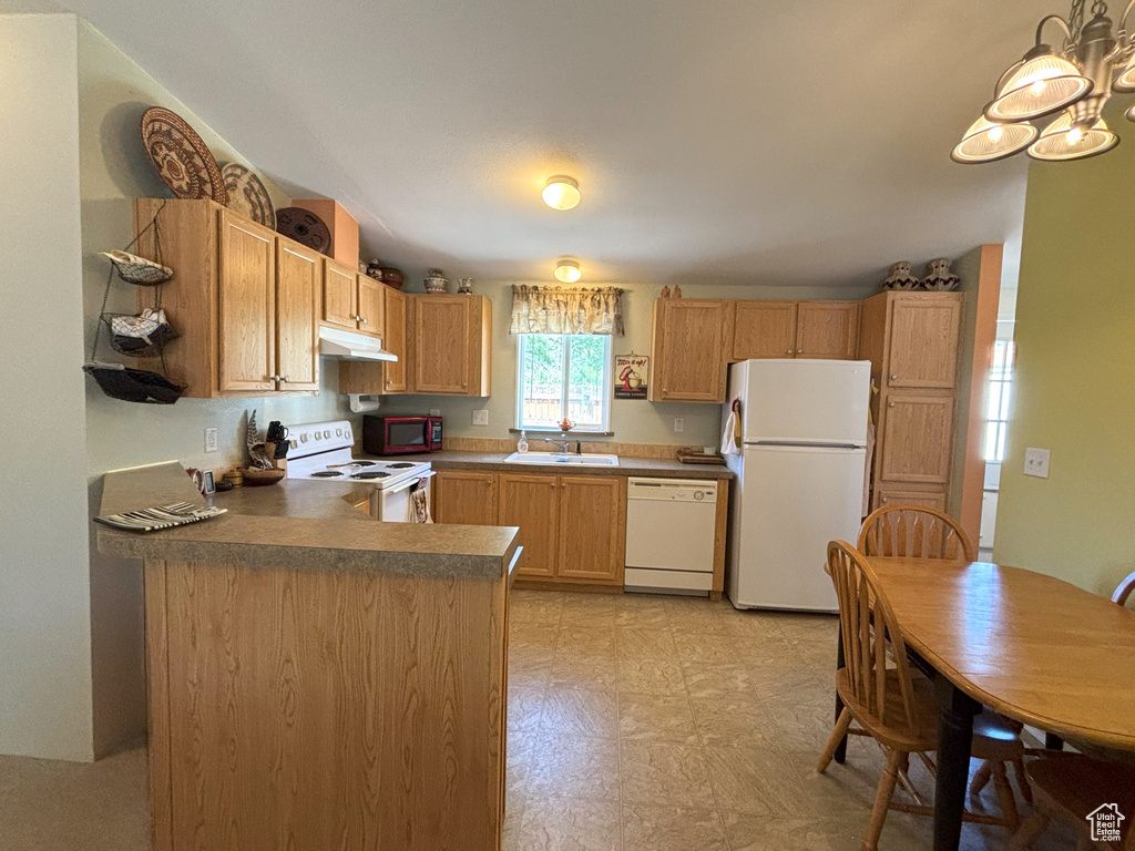 Kitchen featuring white appliances, under cabinet range hood, a peninsula, a sink, and light floors