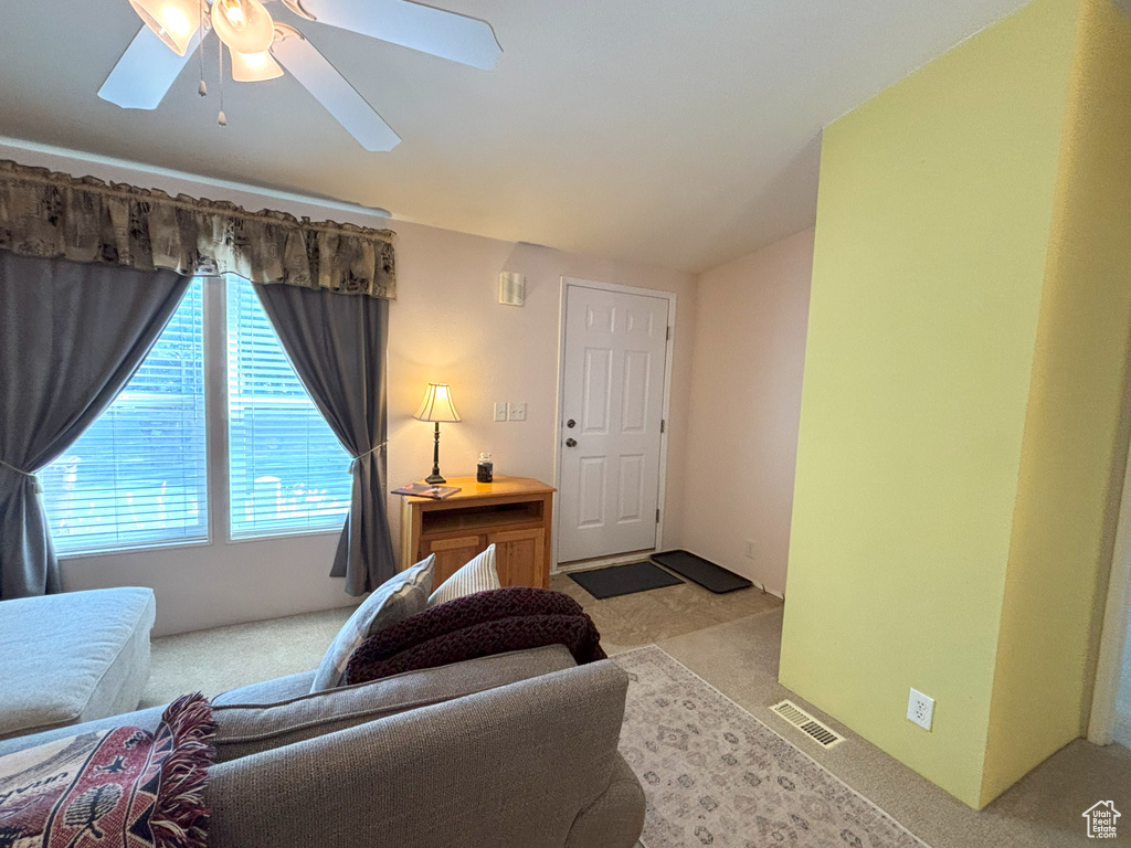 Living room featuring ceiling fan and light carpet