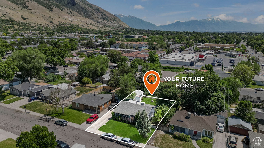 Aerial view of residential area featuring property boundaries highlighted and mountains