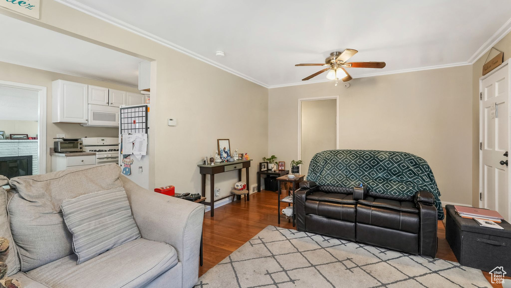 Living area featuring a ceiling fan, light wood-style floors, and ornamental molding