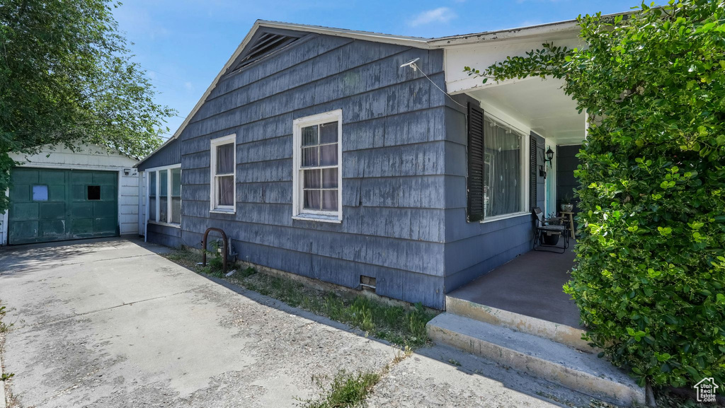View of side of property with crawl space, an outdoor structure, and a garage