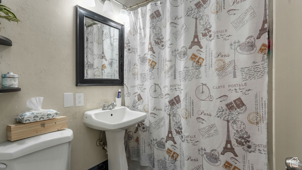 Full bathroom featuring toilet and curtained shower