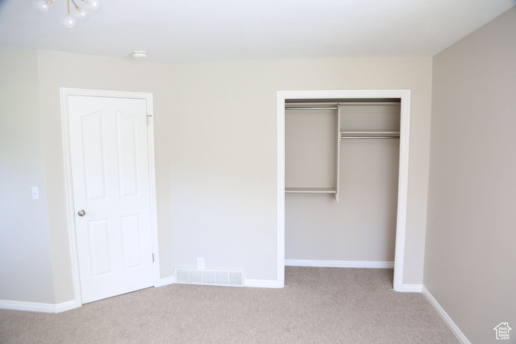 Unfurnished bedroom with carpet floors, a closet, and baseboards