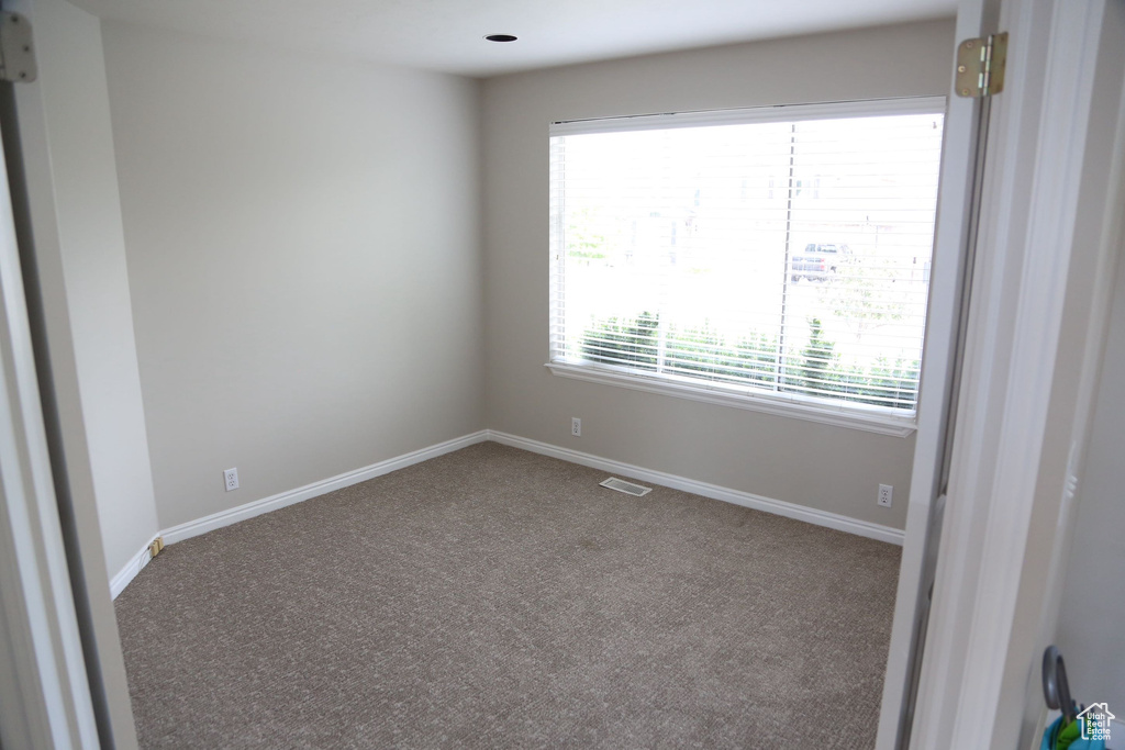 Carpeted empty room featuring baseboards