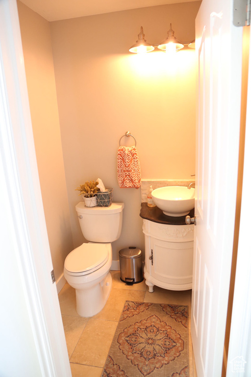 Half bath featuring vanity, tile patterned floors, and toilet