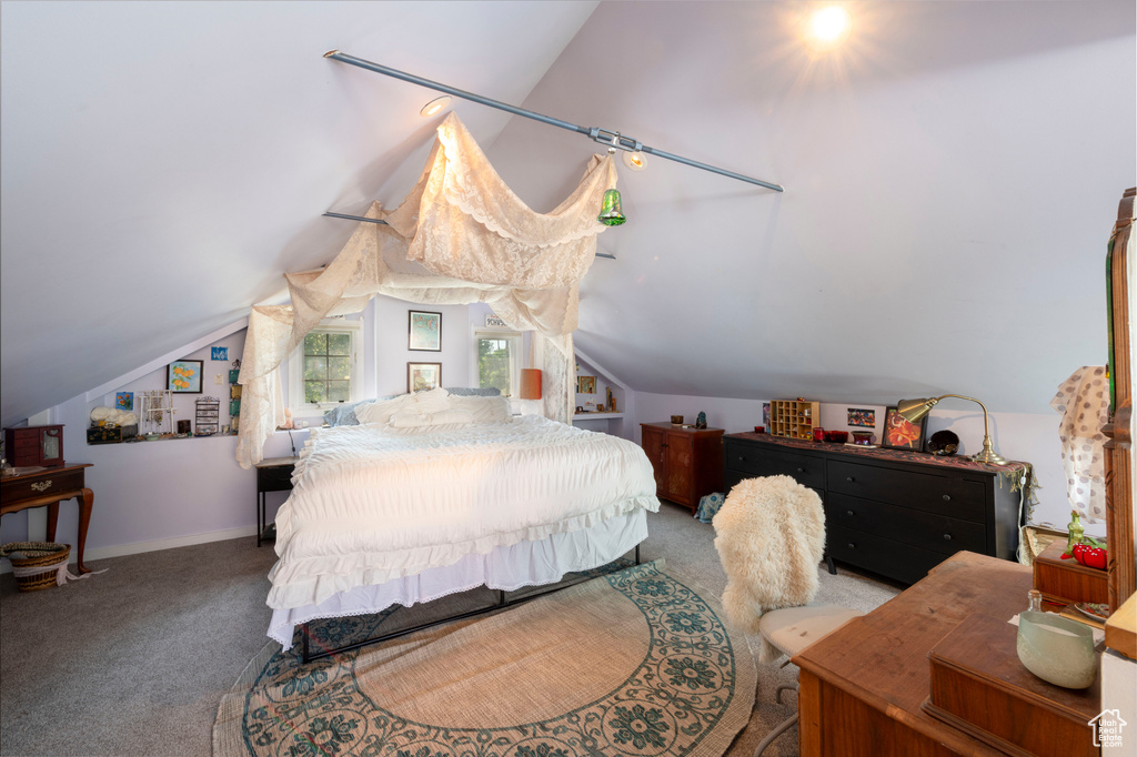 Carpeted bedroom with lofted ceiling and baseboards