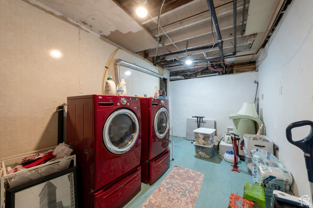 Washroom with washing machine and dryer and tile patterned floors
