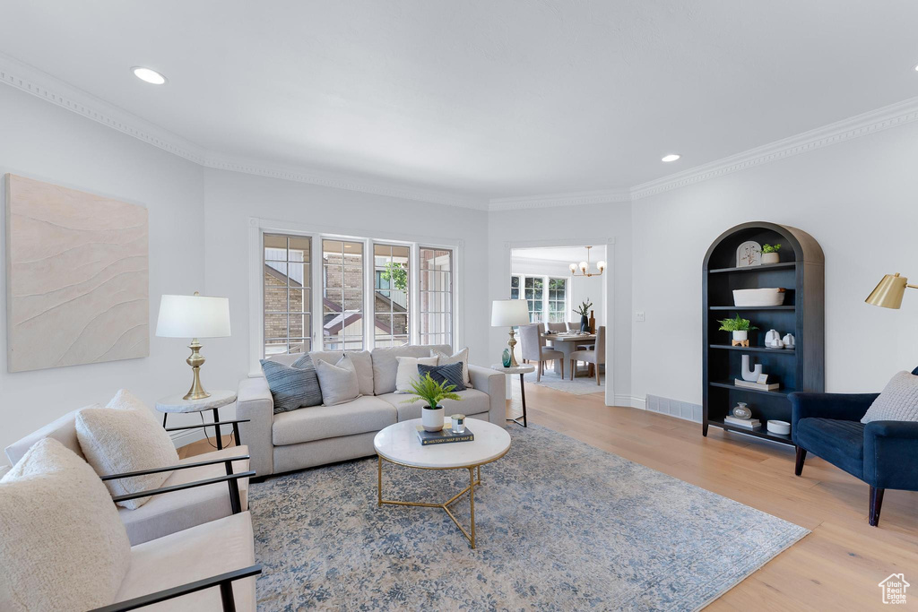 Living area featuring wood finished floors, crown molding, a chandelier, recessed lighting, and baseboards