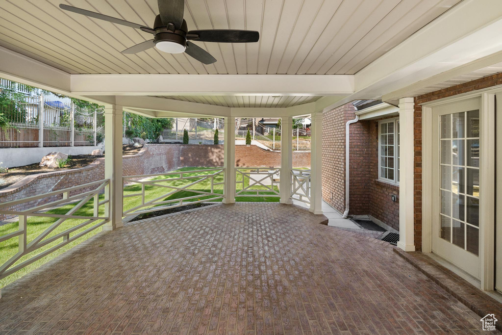 Unfurnished sunroom featuring ceiling fan and beam ceiling