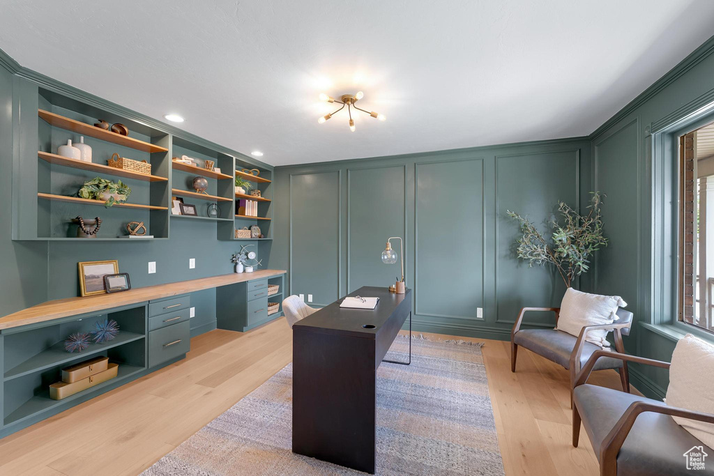 Office featuring a decorative wall, built in desk, light wood finished floors, and recessed lighting