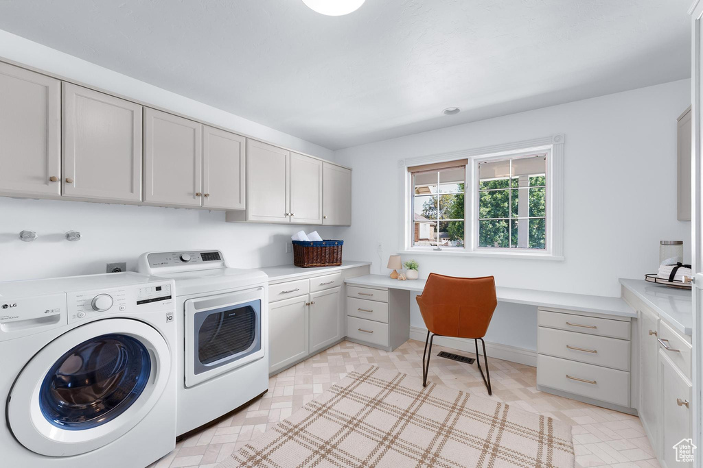 Laundry room featuring separate washer and dryer, cabinet space, and an office area