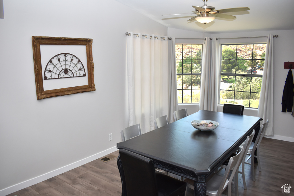 Dining space with baseboards, dark wood-style flooring, ceiling fan, and vaulted ceiling