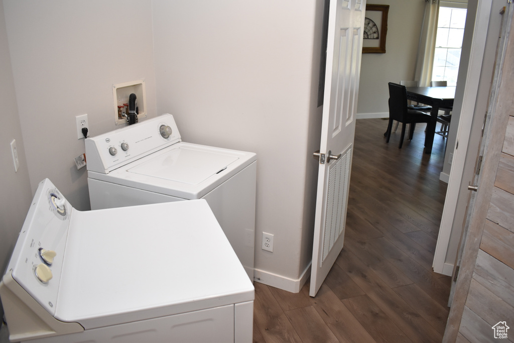 Laundry area with independent washer and dryer, dark wood-style floors, and baseboards