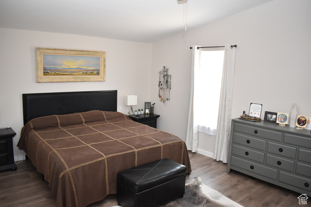 Bedroom featuring dark wood finished floors, lofted ceiling, and baseboards