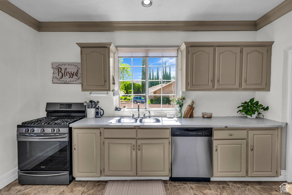 Kitchen with stainless steel appliances, a sink, ornamental molding, light countertops, and baseboards