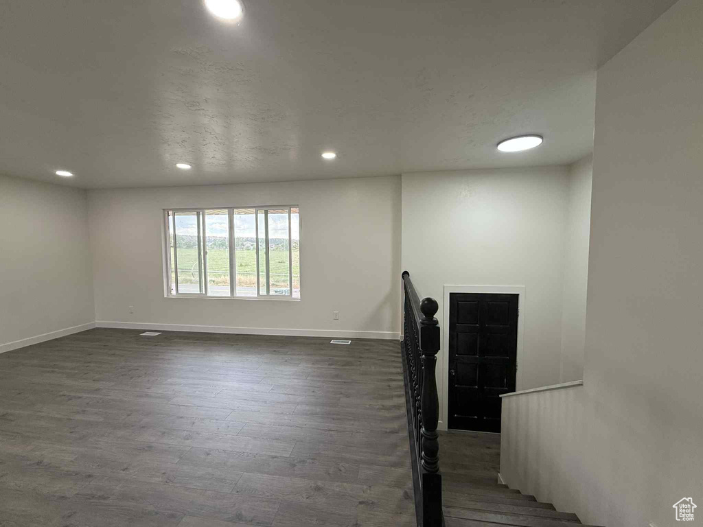 Empty room featuring recessed lighting, dark wood-style flooring, and baseboards