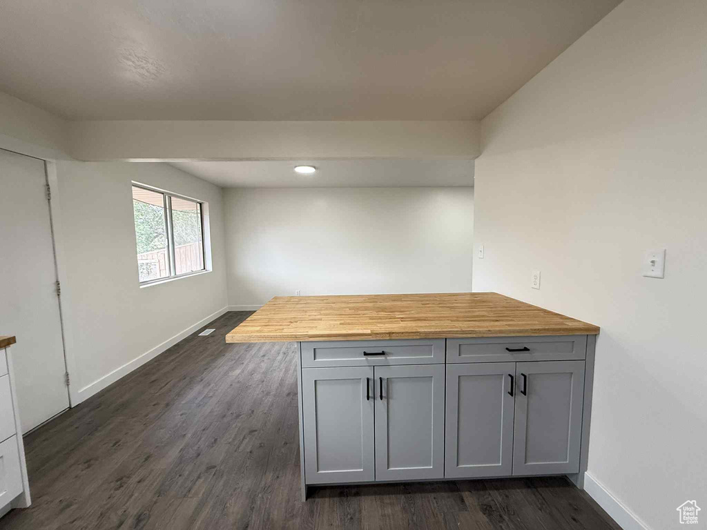 Interior space featuring butcher block countertops, baseboards, dark wood-style flooring, and recessed lighting