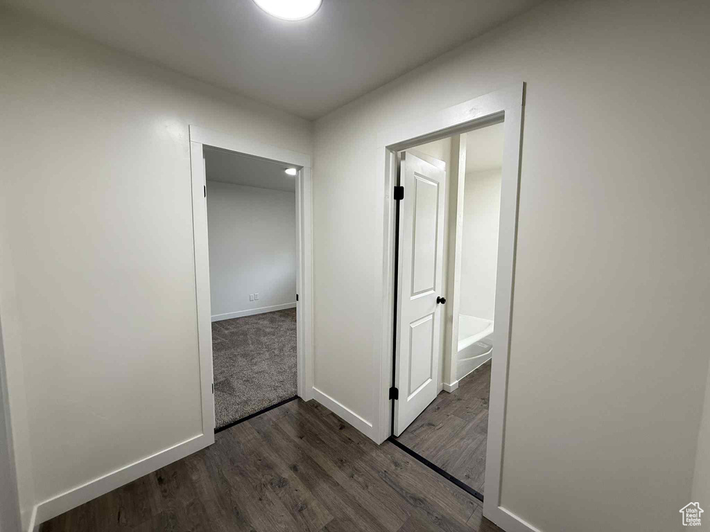 Corridor featuring dark wood-type flooring and baseboards