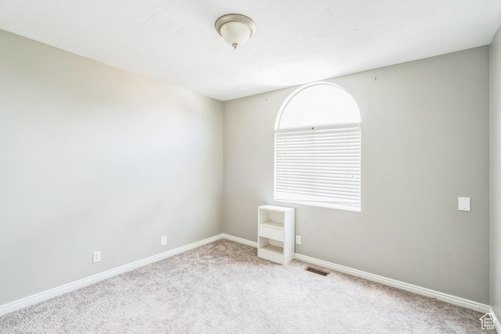 Unfurnished room featuring carpet floors and baseboards