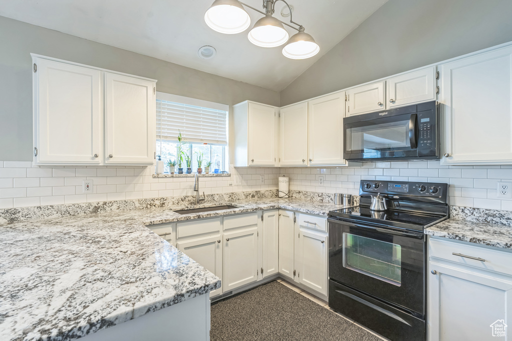 Kitchen featuring black appliances, a sink, lofted ceiling, backsplash, and white cabinetry