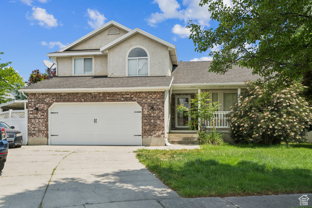 View of front of property with concrete driveway, a porch, a garage, brick siding, and a shingled roof