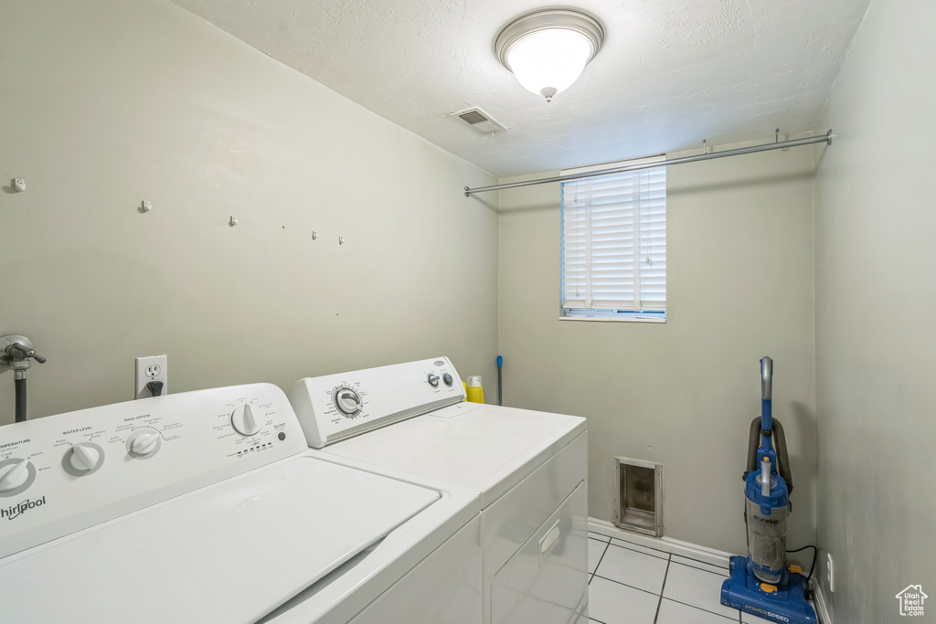Laundry area featuring washer and clothes dryer and light tile patterned flooring