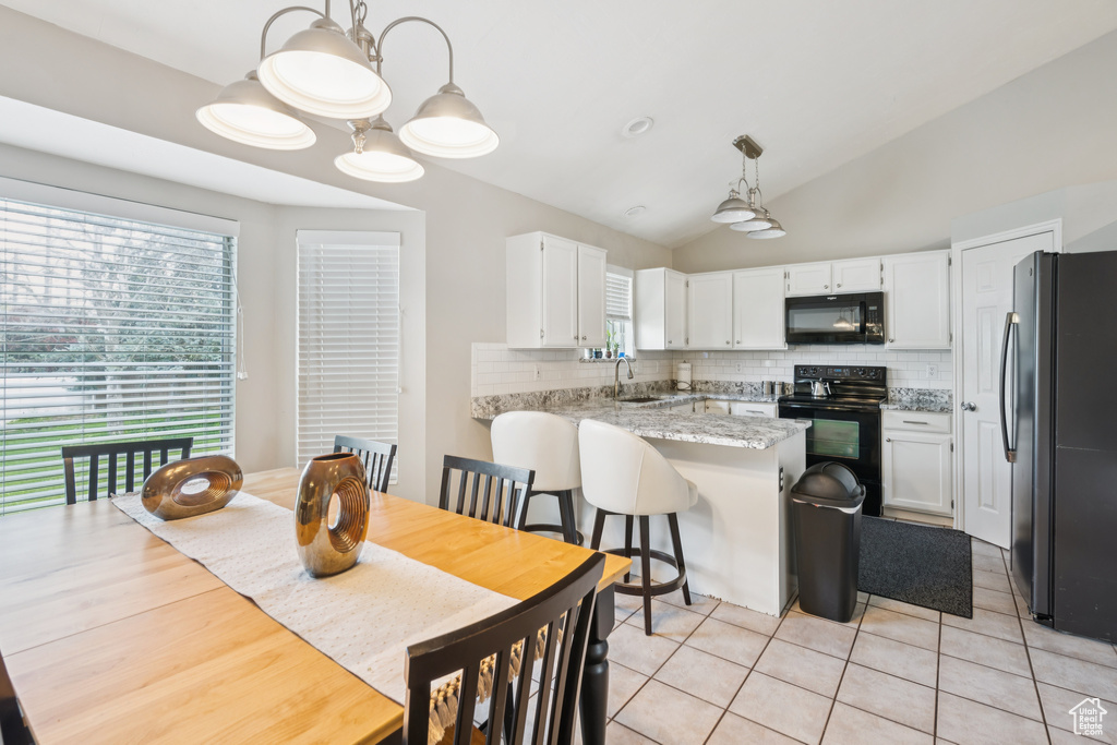 Dining area featuring vaulted ceiling and light tile patterned flooring