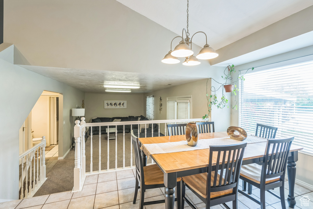 Dining area featuring light tile patterned floors, a chandelier, and baseboards