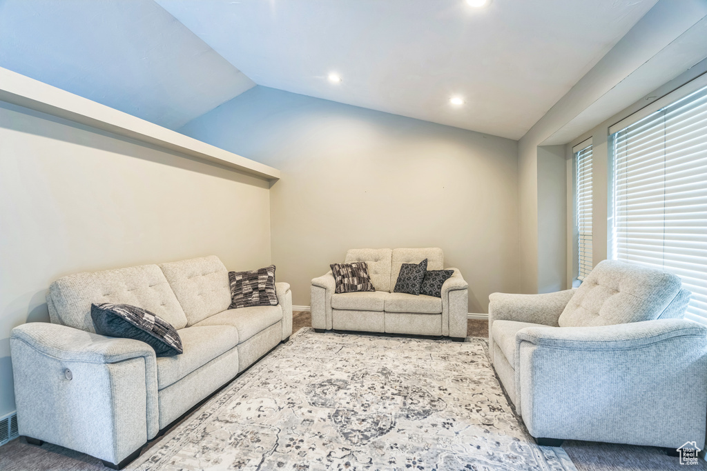 Carpeted living area with baseboards, lofted ceiling, and recessed lighting