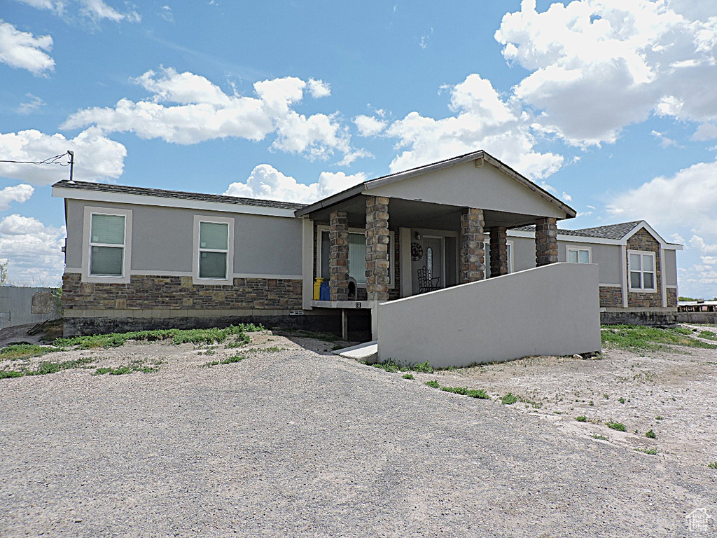 View of front facade featuring stone siding and stucco siding