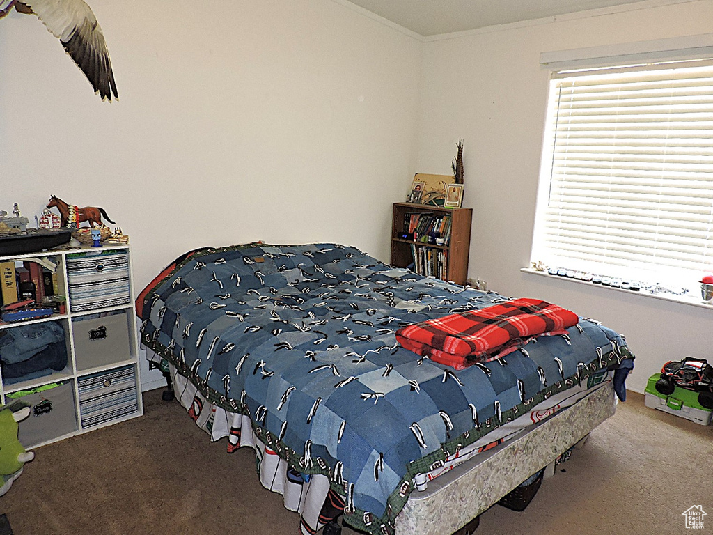 Carpeted bedroom with ornamental molding
