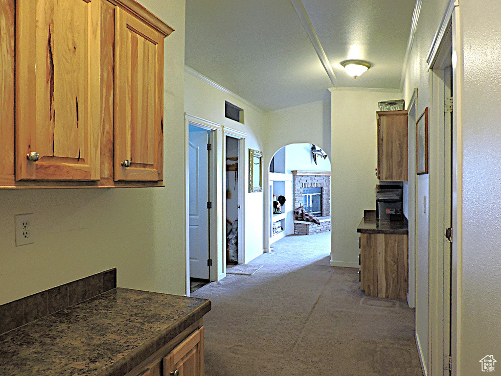 Hallway with carpet, ornamental molding, and arched walkways