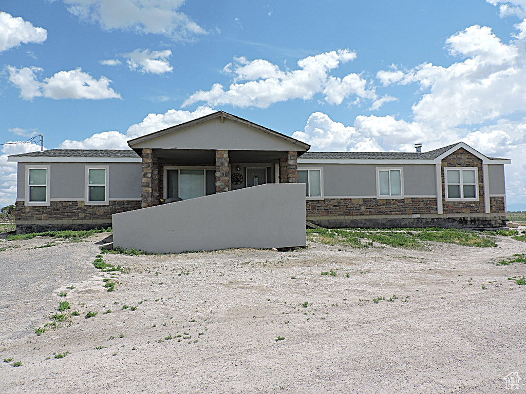 Ranch-style house featuring stone siding and stucco siding
