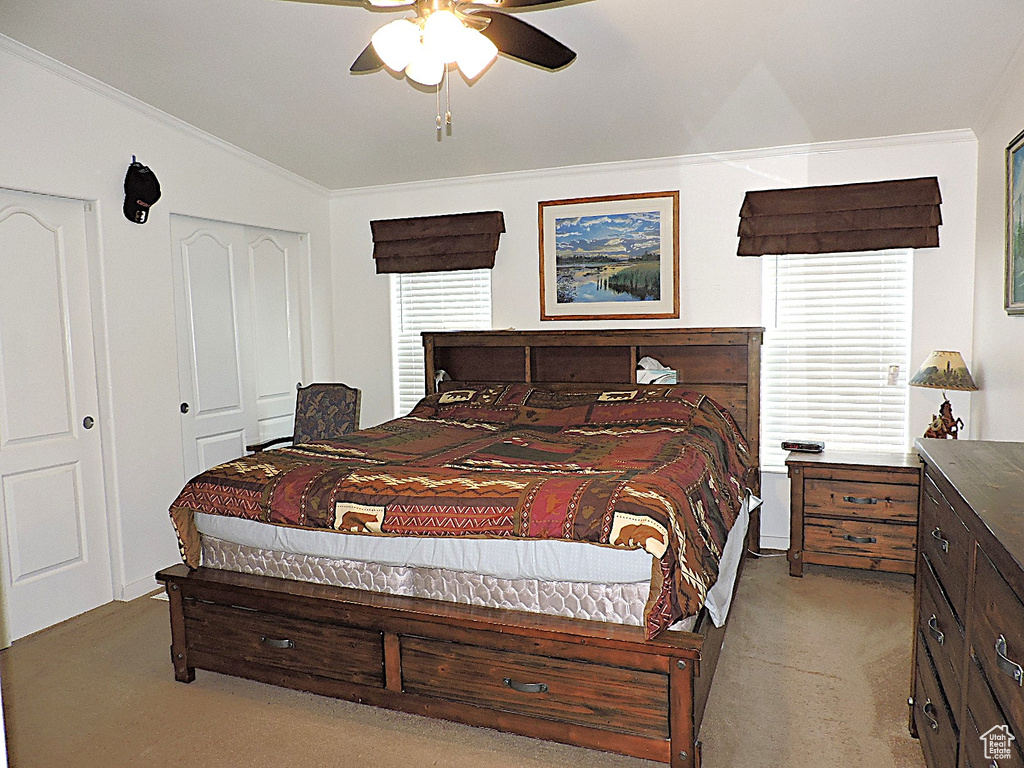 Bedroom featuring light carpet, crown molding, a closet, and ceiling fan