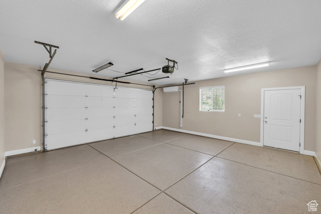 Garage featuring a garage door opener and baseboards