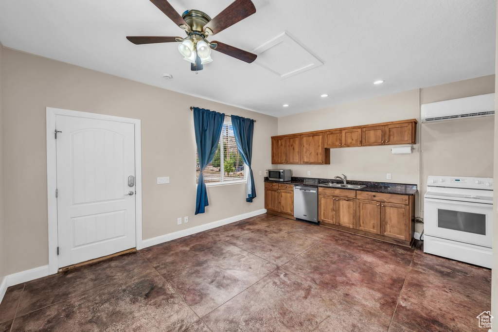 Kitchen with stainless steel appliances, a sink, a wall unit AC, dark countertops, and brown cabinetry