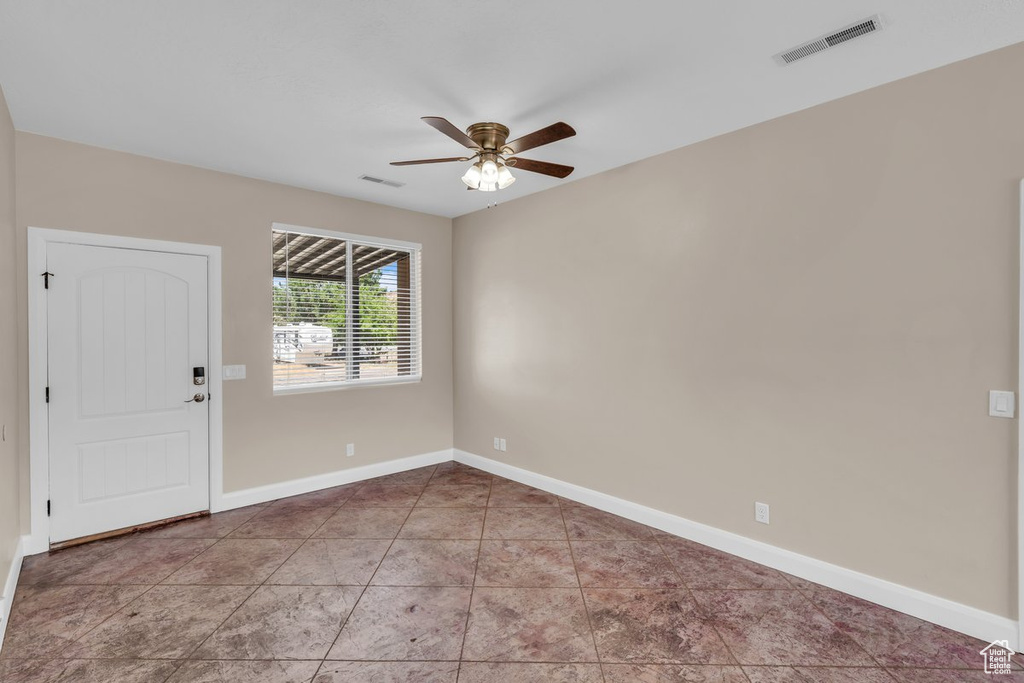 Spare room with ceiling fan and baseboards