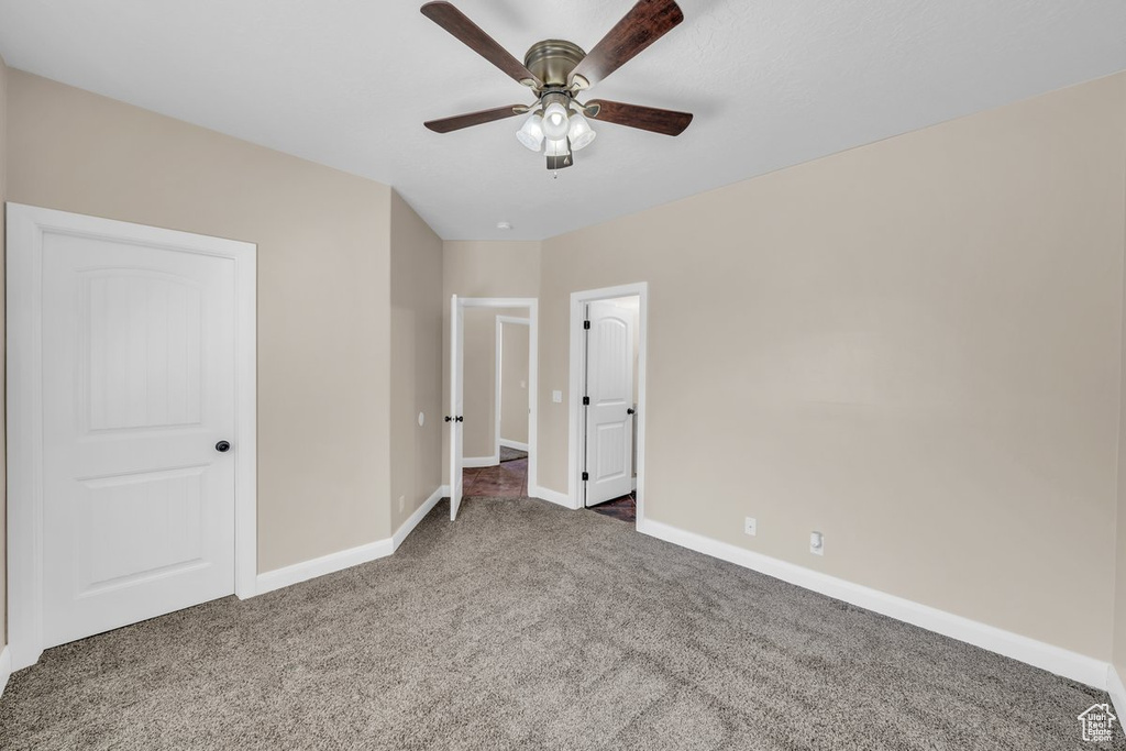 Unfurnished bedroom featuring carpet, baseboards, and a ceiling fan