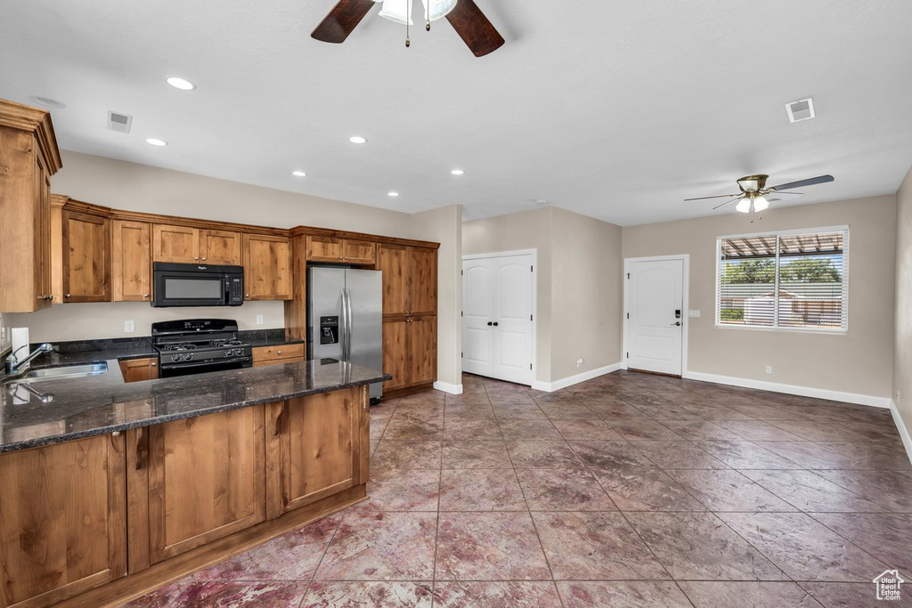 Kitchen with black appliances, ceiling fan, a sink, brown cabinetry, and a peninsula