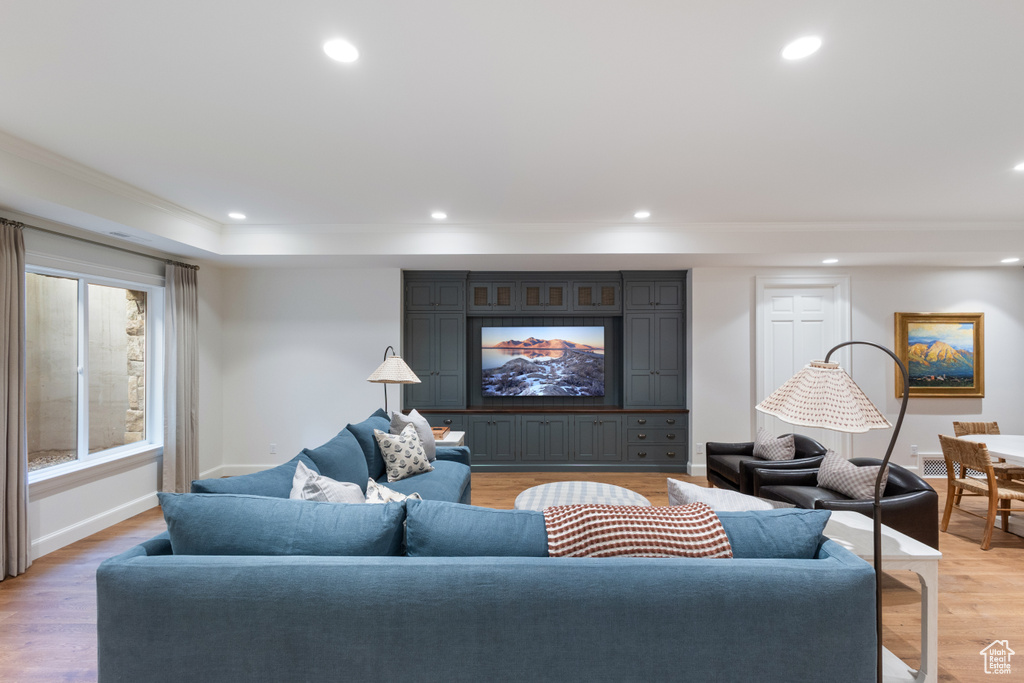 Living area featuring ornamental molding, light wood-style floors, recessed lighting, and baseboards