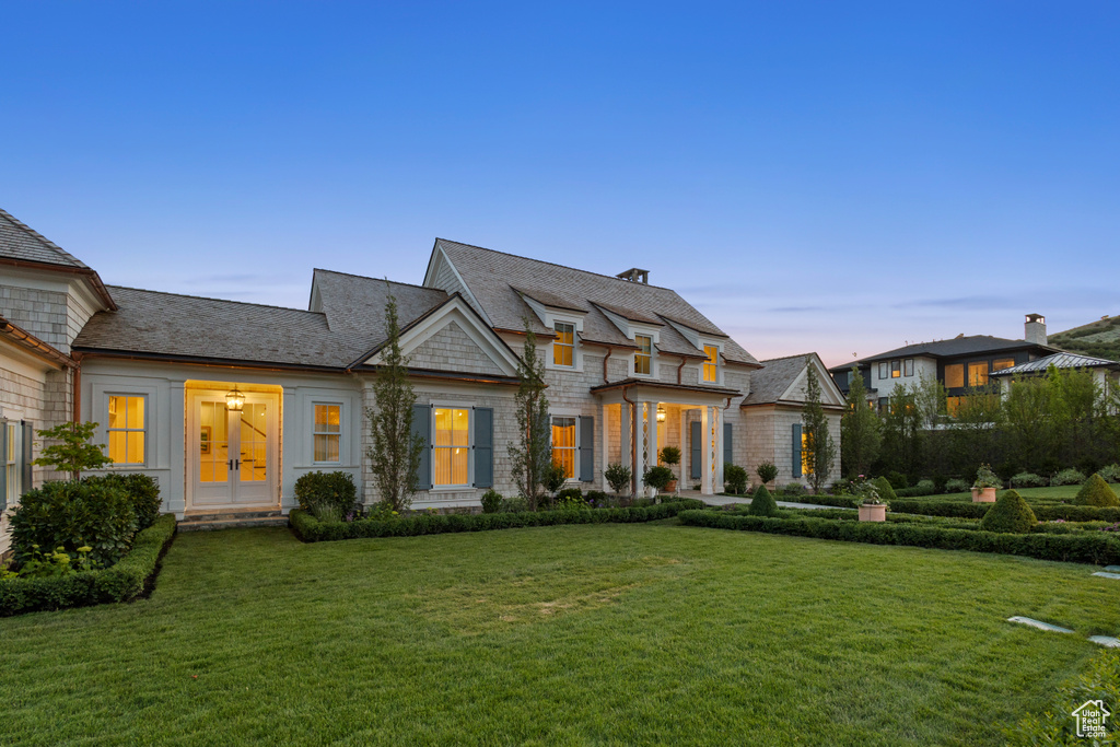 View of front of home with french doors and a yard